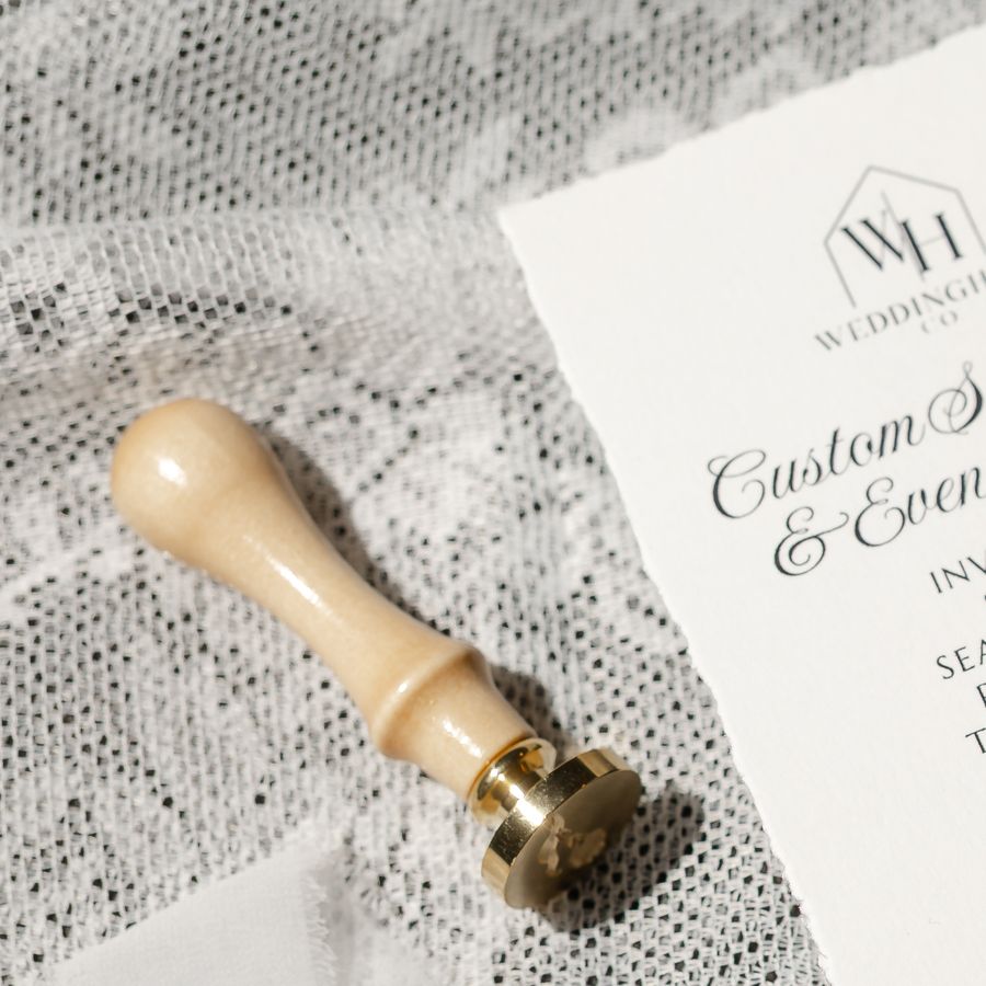 Brass wax seal stamp beside a WeddingHaus Co. card