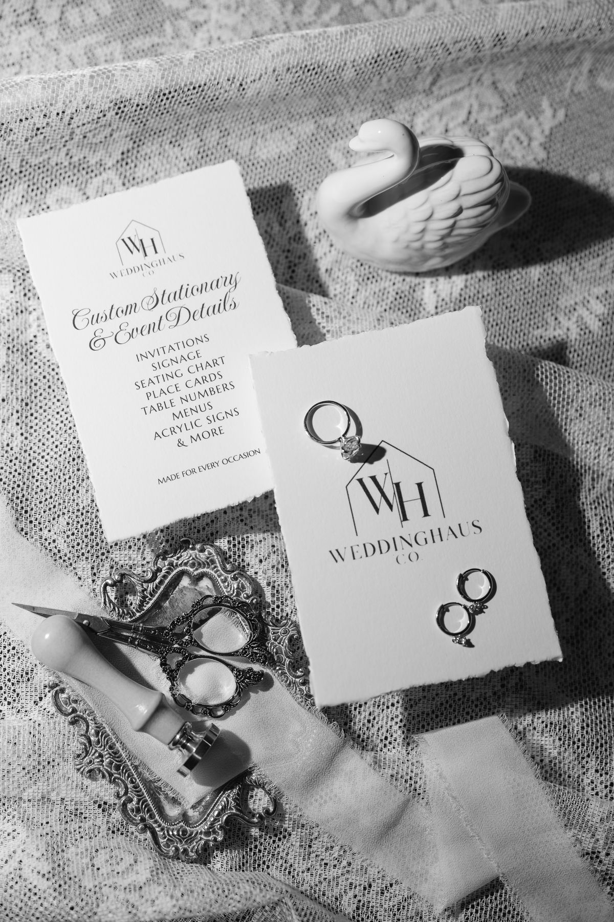 Black and white photo of WeddingHaus Co. cards with rings