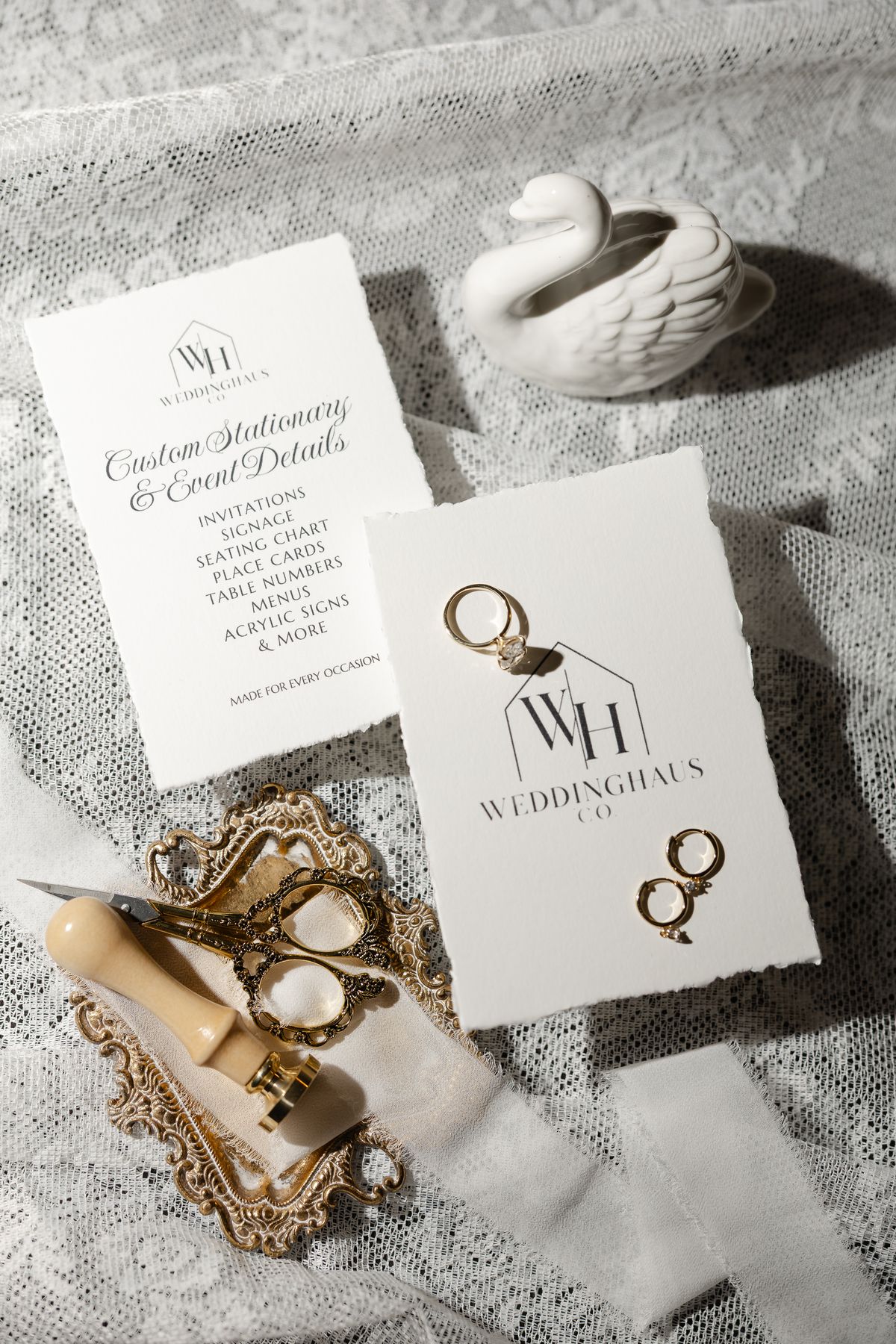 WeddingHaus Co. logo card with gold rings and a wax seal stamp on lace